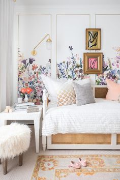 a bedroom with floral wallpaper and white bedding