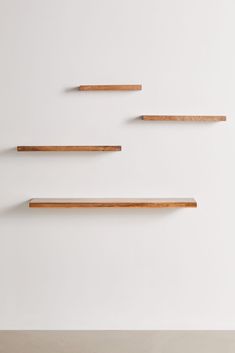 three wooden shelves on the wall with one shelf above them