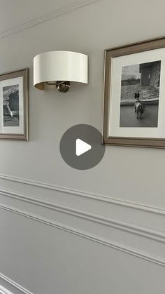 two pictures hanging on the wall next to a lamp