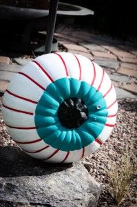 an inflatable ball sitting on top of a rock next to a sidewalk and grass