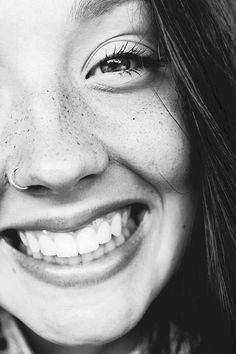 black and white photograph of a woman with freckles on her nose smiling at the camera