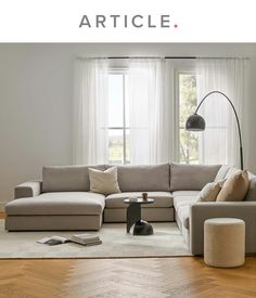 a living room filled with furniture and a large white couch in front of a window