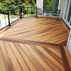 a wooden deck with chairs and table on it