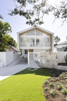 a house that is next to a fence and some grass in front of the house