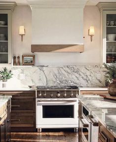 a white stove top oven sitting inside of a kitchen next to wooden cabinets and counter tops