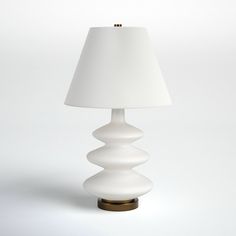 a white lamp with a gold base and a white shade on the top is sitting in front of a white background