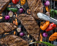 steaks and vegetables are cooking on the grill