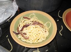 a plate with noodles and sauce on it sitting on a table next to other dishes