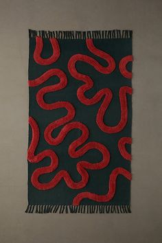 a black and red wall hanging on the side of a wall next to a toilet