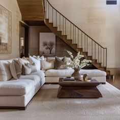 a living room filled with furniture and a stair case next to a table on top of a rug