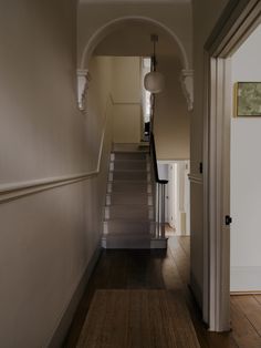 an empty hallway with stairs leading to another room