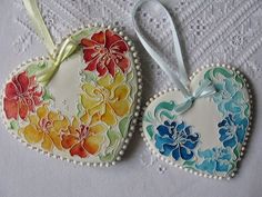 two decorated heart shaped cookies sitting on top of a table