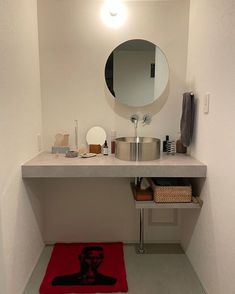 a bathroom with a sink, mirror and towel on the counter top in front of it