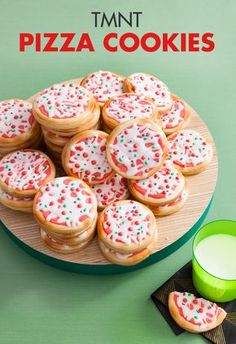 a plate full of cookies with sprinkles on them next to a glass of milk