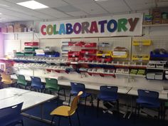 an empty classroom with tables and chairs in front of the wall that says laboratory on it