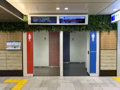 there are two blue and red doors in the building with plants growing on it's sides