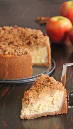 a piece of cake sitting on top of a wooden table next to some sliced apples