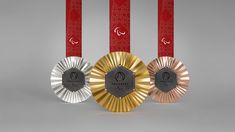 three gold, silver and bronze medals with red ribbons