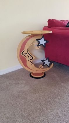 a red couch sitting in a living room next to a wooden table with stars on it