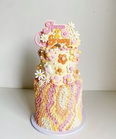 a three tiered cake decorated with flowers and icing