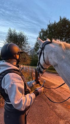 a person riding on the back of a white horse