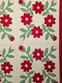 a red and green quilt with flowers on it