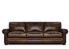 a brown leather couch sitting on top of a white floor