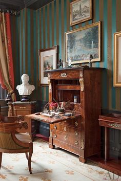 an antique desk and chair in a room with striped walls