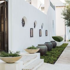 a row of planters sitting on the side of a white building next to steps