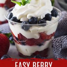 easy berry cheesecake cups with whipped cream and blueberries in a glass dish on a table