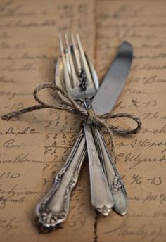 silverware tied up on top of an old letter