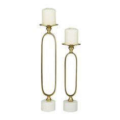 two brass candlesticks with white candle holders