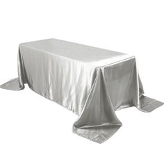 a table covered in silver cloth on top of a white surface with an open end