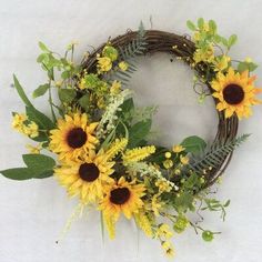 a wreath with sunflowers and greenery on it