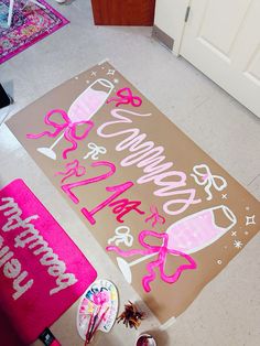 a happy birthday sign is on the floor next to a pink towel and cupcakes