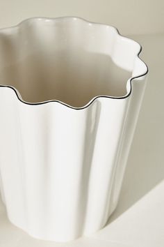 a white vase sitting on top of a table