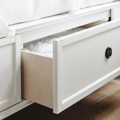 a white bed with drawers underneath it