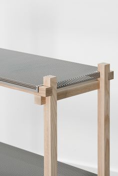 the table is made out of wood and has a metal surface on top, with holes in it