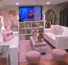 a living room filled with white furniture and pink pillows on top of it's couches