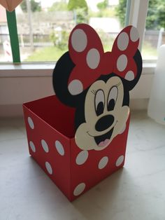 a red box with a minnie mouse cutout on the side and polka dots around it