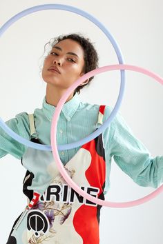 a woman is holding two hoop rings in front of her face