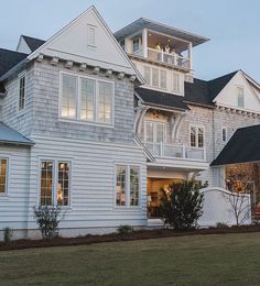 a large white house sitting on top of a lush green field