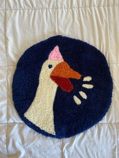 a blue rug with a white duck on it's side and a pink nose