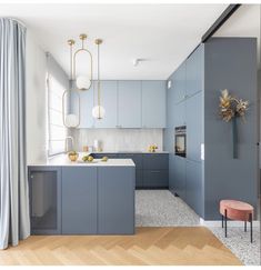 a kitchen with blue cabinets and white counter tops