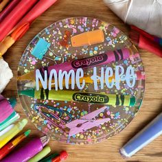 a personalized glass plate surrounded by crayons and markers