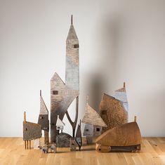 a group of wooden houses sitting on top of a hard wood floor next to a white wall