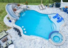 an aerial view of a pool with lounge chairs and a slide in the back yard