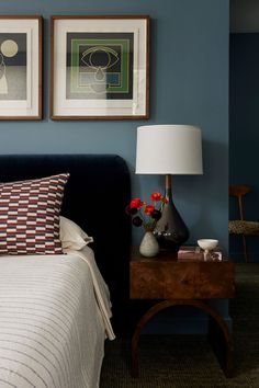 a bedroom with blue walls and pictures on the wall