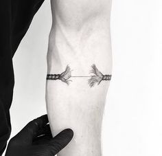 an arrow tattoo on the left leg