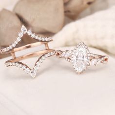 two wedding rings, one with a pear shaped diamond and the other with an arrow